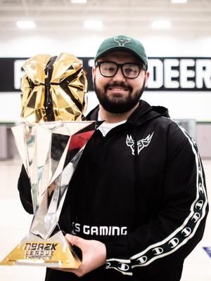 Coach Lance in Bucks Gaming gear holding the NBA 2K League championship trophy