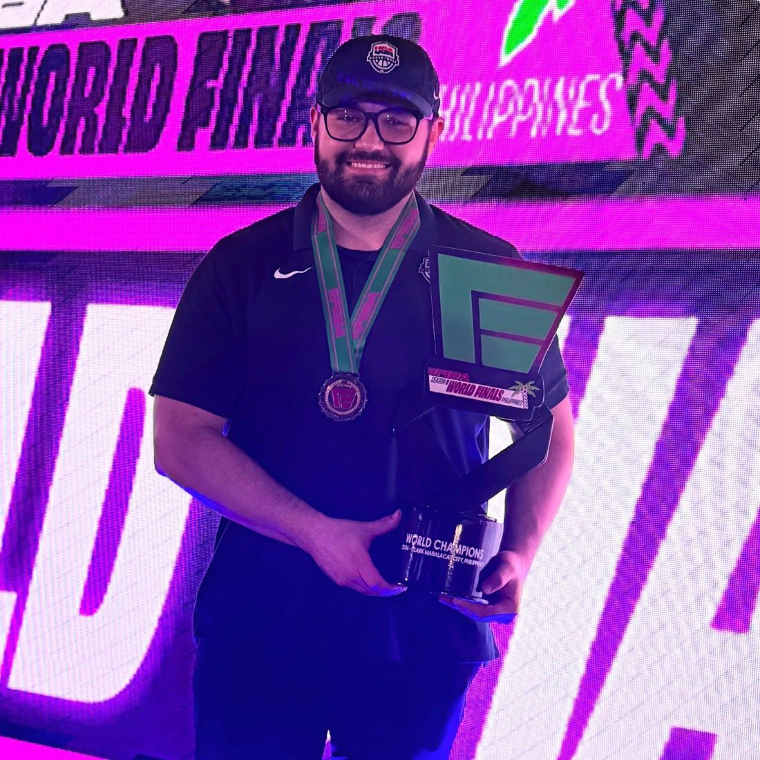 Coach Lance holding the World Champions trophy at the eFIBA World Finals in the Philippines